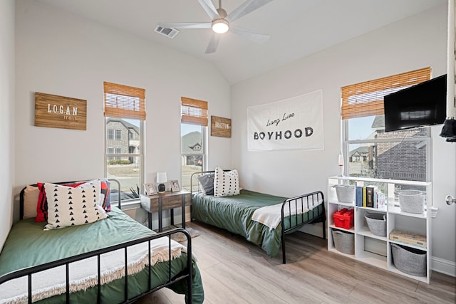 bedroom featuring visible vents, ceiling fan, vaulted ceiling, wood finished floors, and baseboards