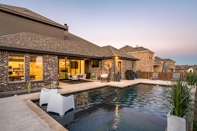 view of swimming pool featuring a grill, fence, a fenced in pool, and a patio