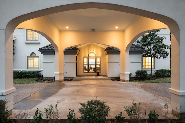 entrance to property featuring french doors, a tile roof, and stucco siding