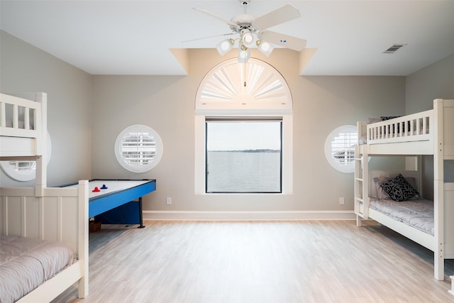 bedroom with visible vents, baseboards, and wood finished floors