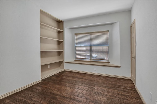 empty room featuring baseboards and wood finished floors