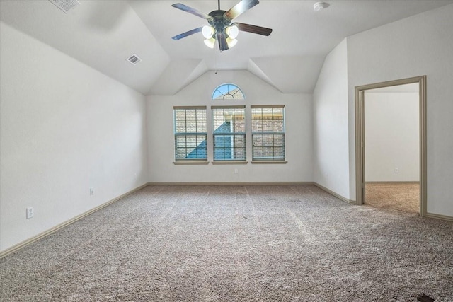 carpeted spare room featuring lofted ceiling, baseboards, visible vents, and a ceiling fan