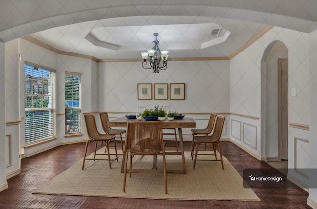 dining space with visible vents, arched walkways, wood finished floors, an inviting chandelier, and crown molding