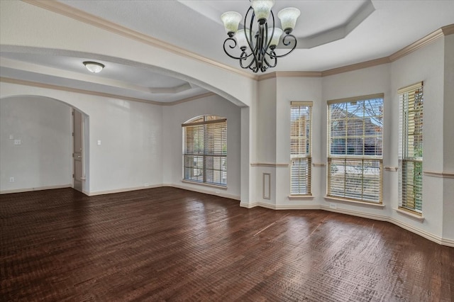 unfurnished dining area with a tray ceiling, a notable chandelier, arched walkways, and baseboards