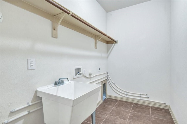 clothes washing area featuring washer hookup, hookup for a gas dryer, electric dryer hookup, dark tile patterned flooring, and laundry area