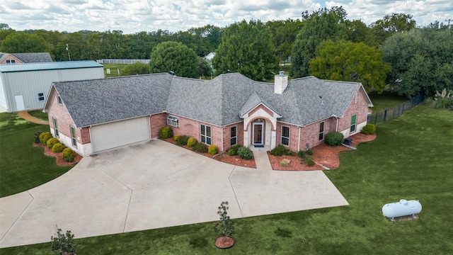 view of front of house with a garage, brick siding, concrete driveway, a front lawn, and a chimney