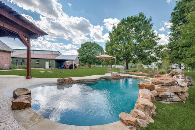 pool featuring a lawn, a patio, and fence