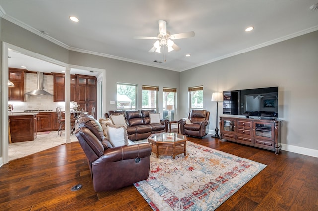 living room featuring a ceiling fan, light wood-style flooring, baseboards, and crown molding