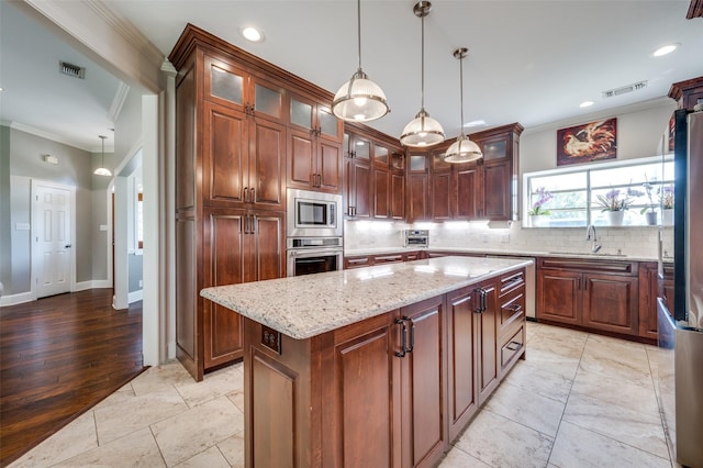 kitchen with appliances with stainless steel finishes, visible vents, crown molding, and a sink