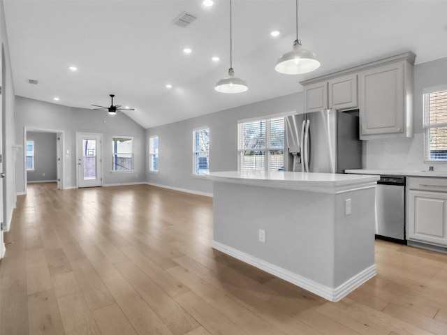 kitchen with stainless steel appliances, light countertops, visible vents, and a healthy amount of sunlight