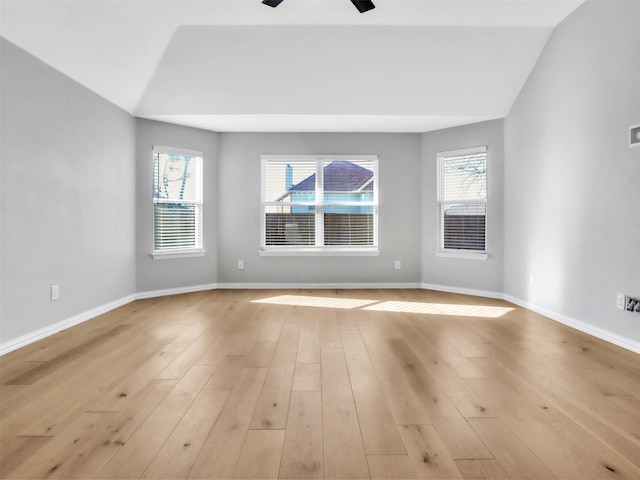 unfurnished room featuring light wood-style floors, vaulted ceiling, and baseboards