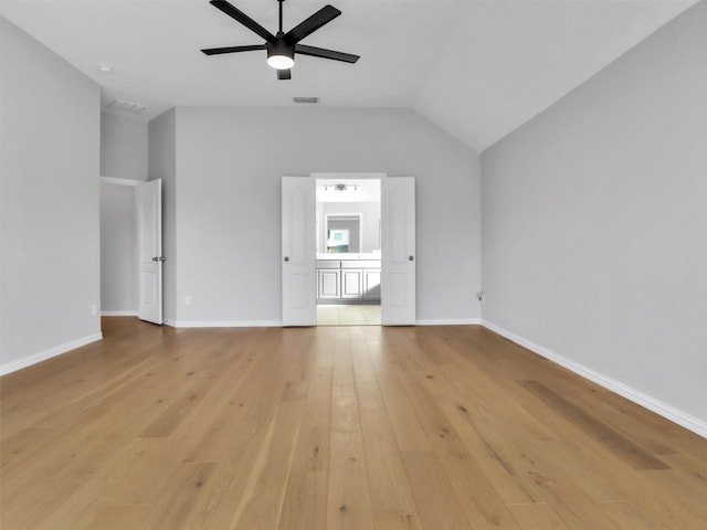 interior space featuring lofted ceiling, light wood finished floors, baseboards, and visible vents