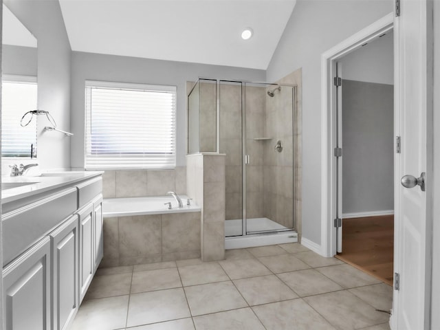 bathroom featuring lofted ceiling, a stall shower, tile patterned flooring, and a bath