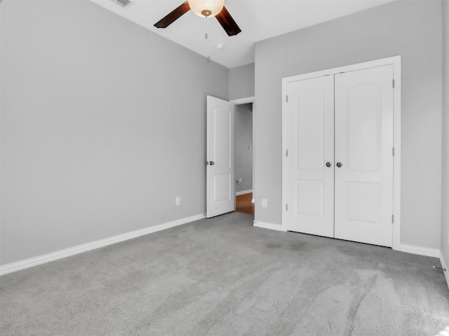 unfurnished bedroom featuring a closet, carpet flooring, a ceiling fan, and baseboards