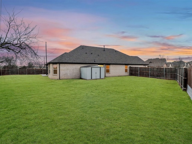 view of yard with a shed, a fenced backyard, and an outdoor structure