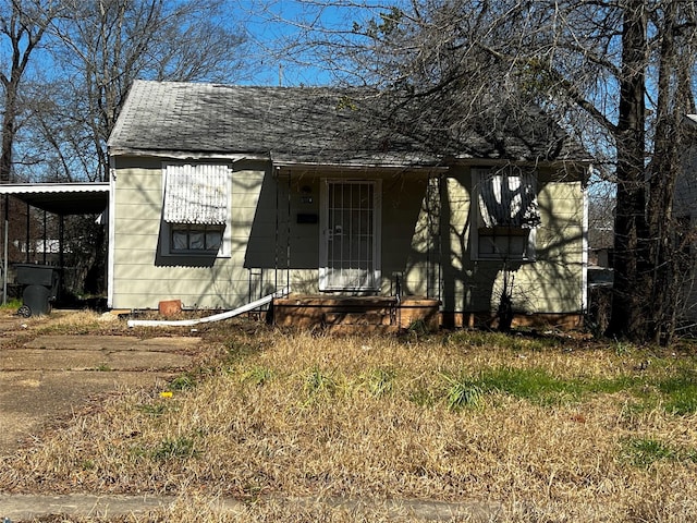 view of front of home featuring an attached carport and roof with shingles