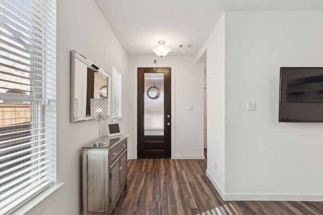 entryway with dark wood-type flooring, visible vents, and baseboards