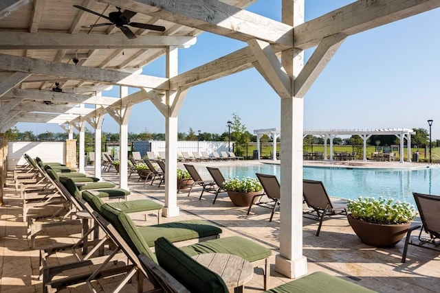 view of patio / terrace with ceiling fan, a community pool, fence, and a pergola