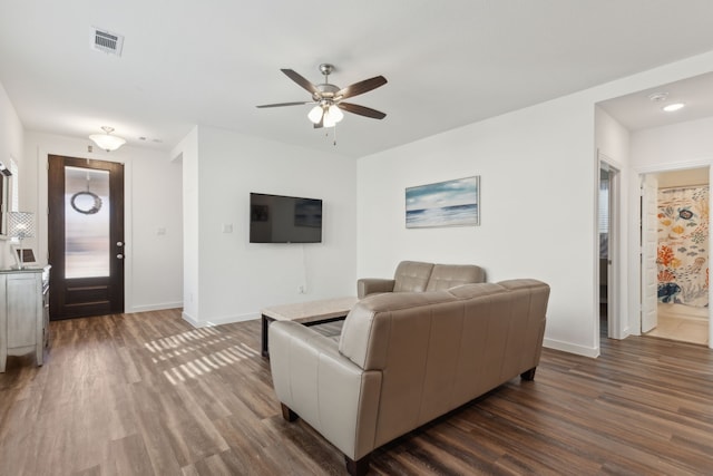 living room with a ceiling fan, dark wood-style flooring, visible vents, and baseboards