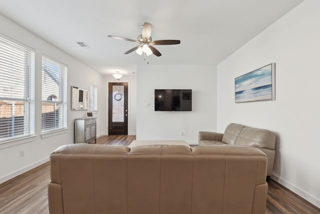 living area featuring dark wood-style floors, ceiling fan, and baseboards