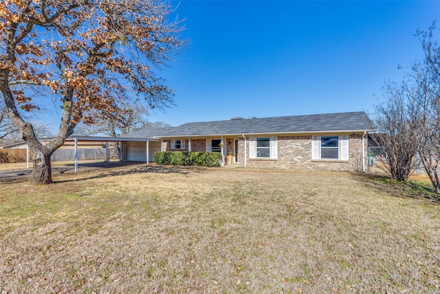 ranch-style house featuring brick siding, fence, a carport, and a front yard