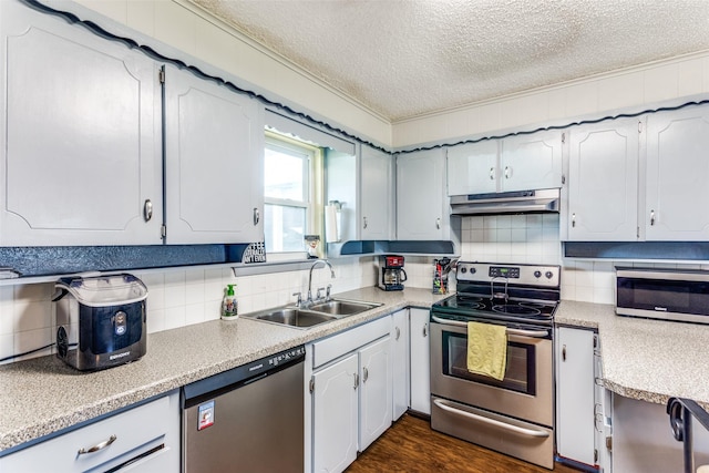 kitchen featuring under cabinet range hood, a sink, light countertops, appliances with stainless steel finishes, and backsplash