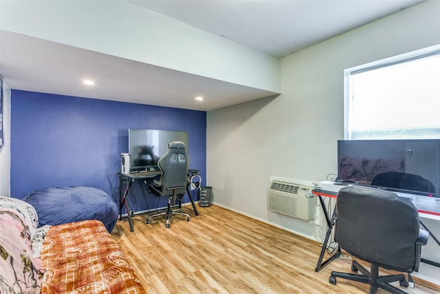 office featuring baseboards, wood finished floors, and an AC wall unit