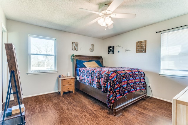 bedroom with a textured ceiling, baseboards, and wood finished floors