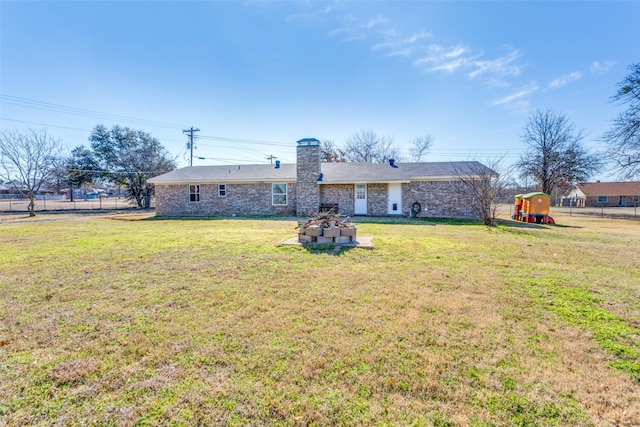 back of house featuring a chimney, fence, and a yard