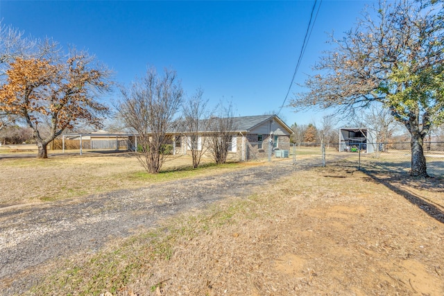 view of front of home featuring driveway, a gate, fence, and a carport