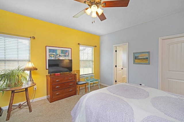 bedroom featuring ensuite bath, ceiling fan, baseboards, and light colored carpet