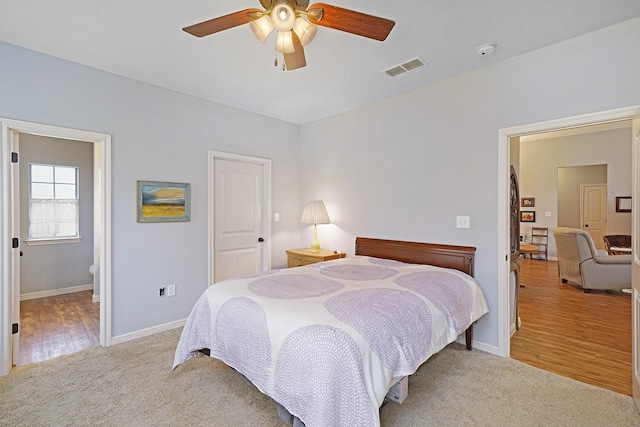 bedroom featuring visible vents, baseboards, a ceiling fan, wood finished floors, and carpet flooring