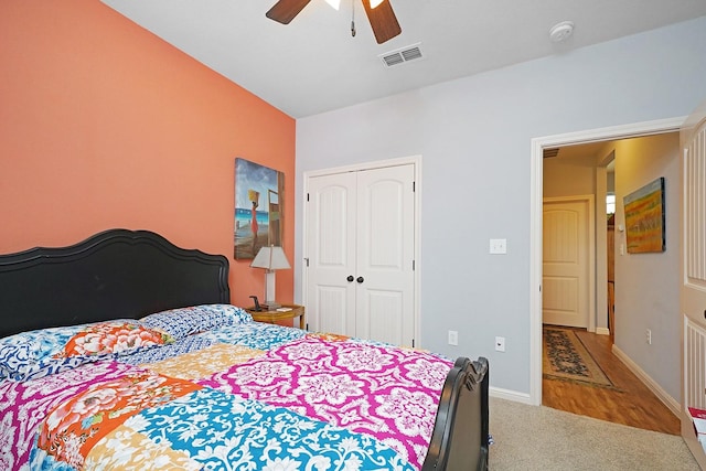 carpeted bedroom with a ceiling fan, baseboards, visible vents, and a closet