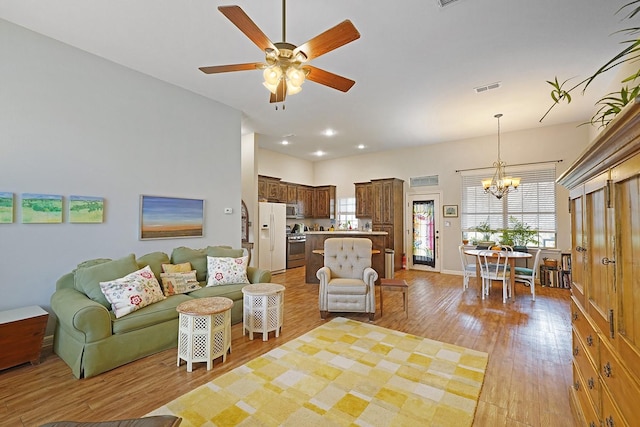 living area with ceiling fan with notable chandelier, light wood finished floors, visible vents, and recessed lighting