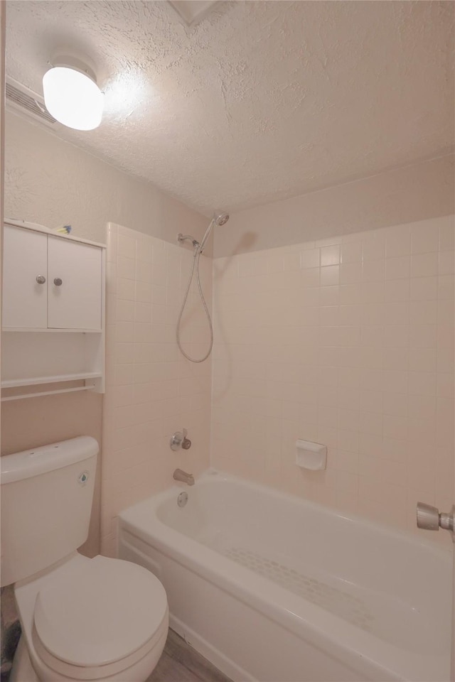 full bathroom featuring toilet, a textured ceiling, and shower / bathtub combination