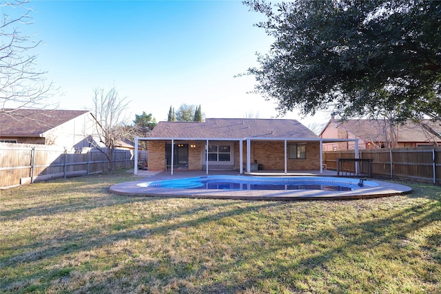 rear view of property featuring a yard, a patio, a fenced backyard, and a fenced in pool