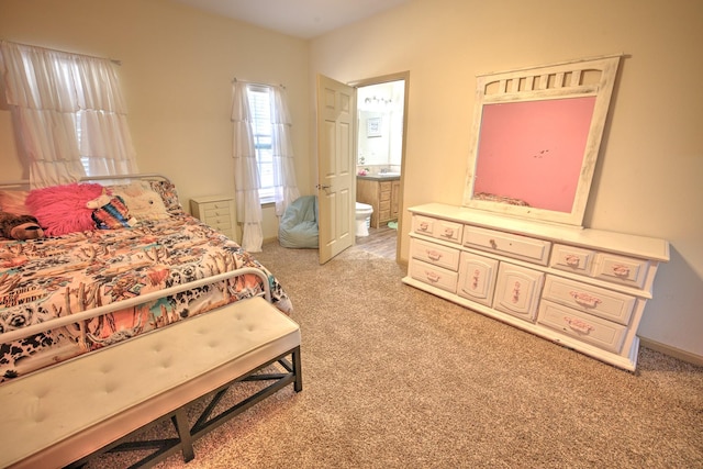 bedroom featuring ensuite bath and light colored carpet