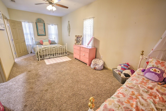 bedroom featuring baseboards, carpet, visible vents, and a ceiling fan