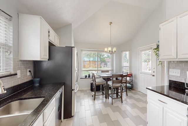 211 Ember Glen Dr, Arlington, TX 76018 - kitchen featuring a sink, healthy amount of natural light, baseboards, lofted ceiling, and white cabinetry