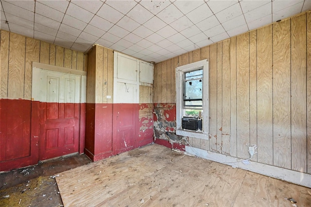 unfurnished room featuring wood walls