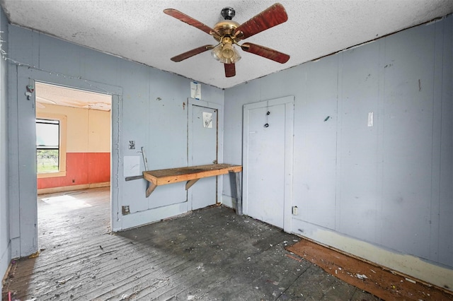 miscellaneous room with ceiling fan and a textured ceiling