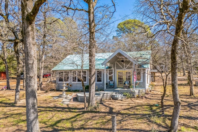 exterior space featuring french doors, metal roof, and a front yard