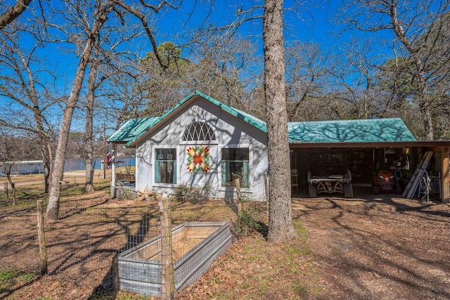 view of front of property featuring a carport and metal roof