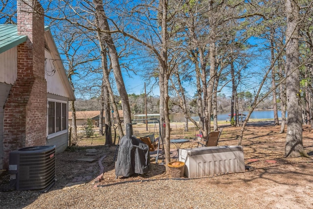 view of yard with a water view and central AC unit