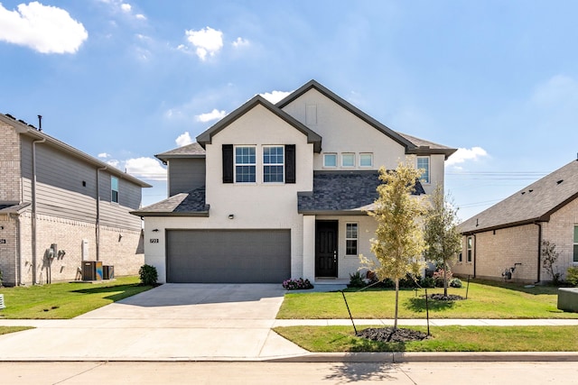 view of front of house featuring a garage, driveway, a front lawn, and a shingled roof