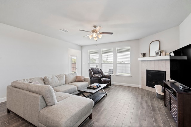 living area with dark wood-style floors, plenty of natural light, visible vents, and baseboards