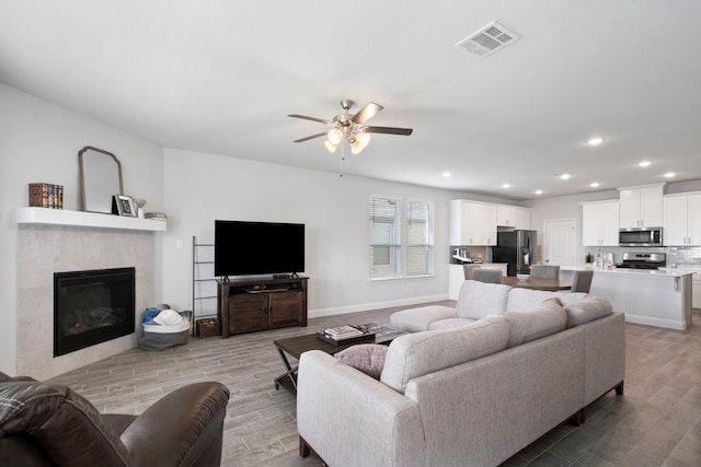 living area with light wood-style floors, baseboards, visible vents, and recessed lighting