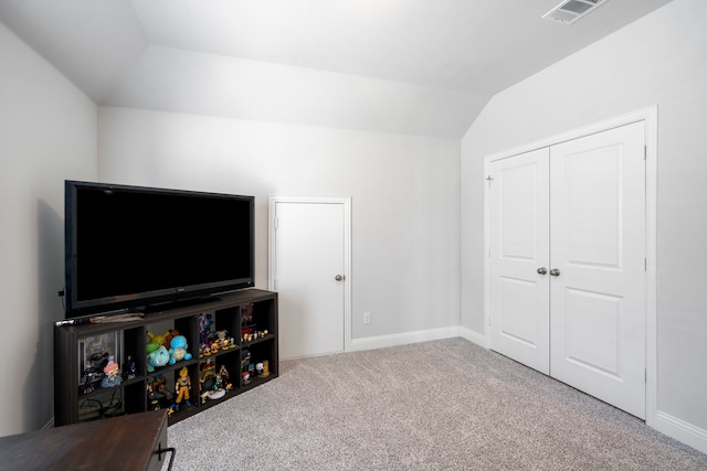 interior space with carpet floors, lofted ceiling, visible vents, and baseboards