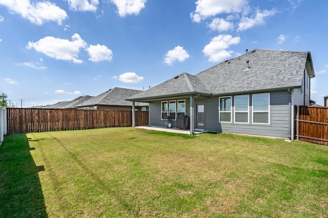 back of property with a yard, a shingled roof, a patio, and a fenced backyard