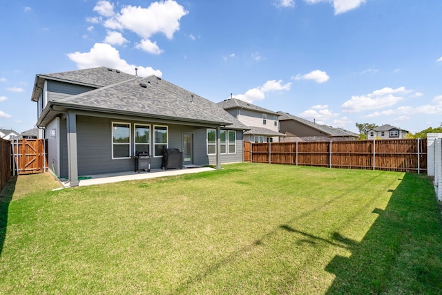 back of house featuring a yard, a fenced backyard, a patio, and roof with shingles